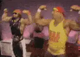 Two wrestlers flexing and shaking hands