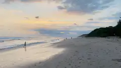 person walking on beach at sunset