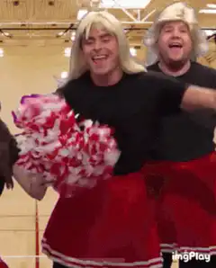 Men in blonde wigs and cheerleader outfits dancing