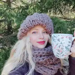 woman in knit hat sipping tea outdoors