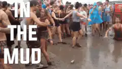 Man crawling through mud at festival