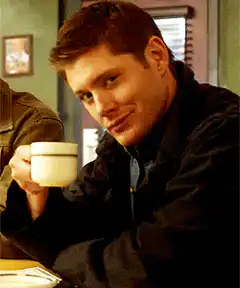 Jensen Ackles smirking with coffee