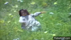 Girl rolling down a grassy hill