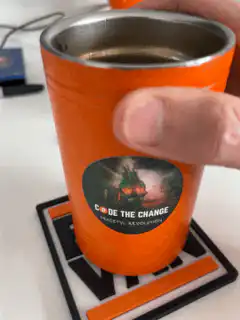 Orange Code the Change cup on BTC VAN coaster
