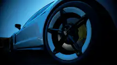 White Porsche Taycan driving away on a track