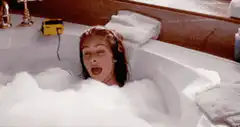 Woman in bathtub with cats