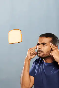 man concentrating on floating toast