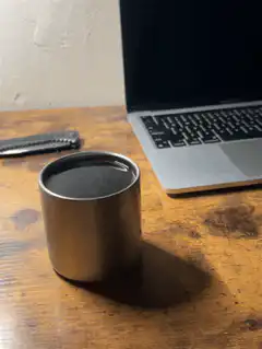 metal cup on wooden desk