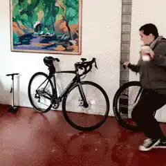 Man dancing with coffee near bikes