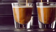Two shot glasses being filled with coffee