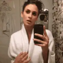 Woman opens bathrobe in mirror selfie