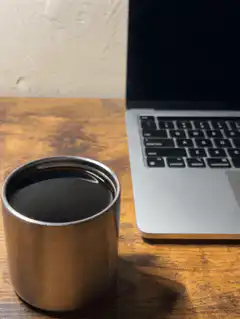 Coffee cup next to laptop