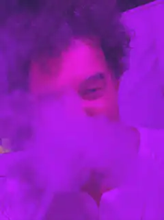 Man exhaling purple smoke