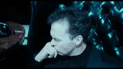 Michael Keaton as Batman looking up at the Bat-Signal