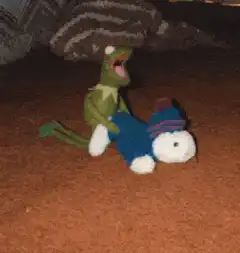 Kermit the Frog puppet on a blue plush toy