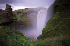misty waterfall in green valley