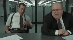Two men laughing hysterically at a desk