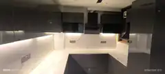 Modern kitchen with marble backsplash and under-cabinet lighting