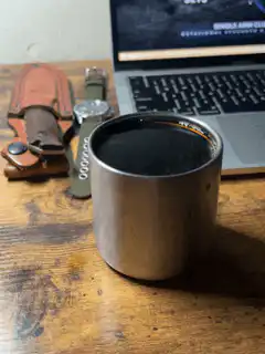 Metal cup on wooden desk