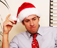 man in santa hat sipping eggnog