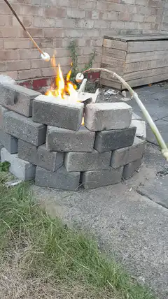 Marshmallows roasting over brick fire pit