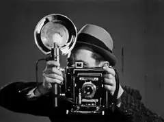 Man with vintage camera and flash
