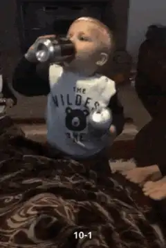 Baby drinking from two cans