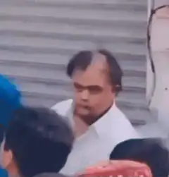 Man puts finger to lips to shush