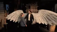 Man with angel wings hugs woman