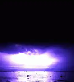 Purple lightning storm over ocean