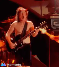Angus Young raises fist to crowd