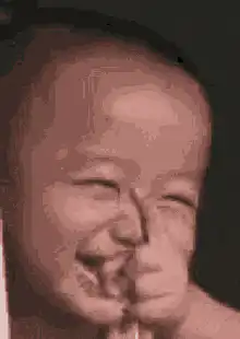 Baby laughing with hand over mouth