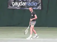 Tennis player hits ball with racket