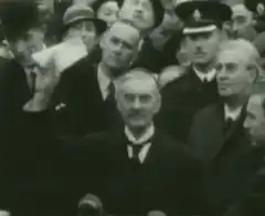 Man in crowd waves paper