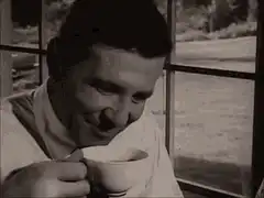 Man laughing while holding a cup