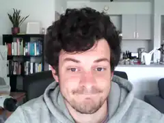 Man with curly hair smirking