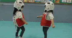 Two kids in taekwondo gear sparring