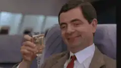 Rowan Atkinson as Mr. Bean toasting with champagne