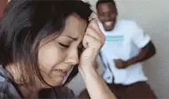 Woman crying while man laughs in background