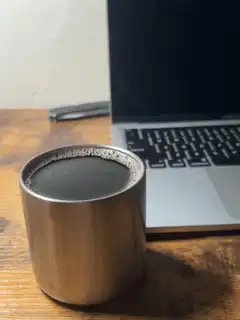 Coffee cup next to laptop