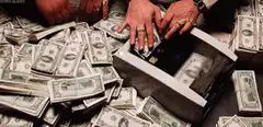 Hands counting stacks of cash with a money counter