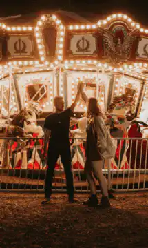 couple high fives at carousel