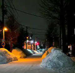 snowy street at night with traffic lights