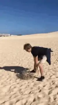 Man kicks sand dune