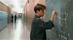 Boy drawing on chalkboard in hallway