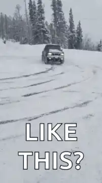Black truck drifting in snow
