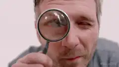 Man looking through magnifying glass