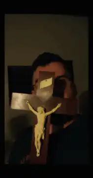 Man holding crucifix and making faces