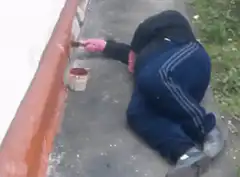 Person painting wall while lying down