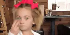 Girl with pink bow pointing at eye